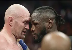  ??  ?? Tyson Fury (izquierda) y Deontay Wilder hablan mientras los jueces deciden el resultado del combate.