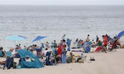  ?? ANGELA ROWLINGS / HERALD STAFF ?? SAFETY IN THE SAND: Beachgoers hang out Wednesday at Nauset Beach in Orleans.