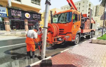  ?? Virendra Saklani/Gulf News ?? Top and above: Sharjah Municipali­ty workers pump out water at Jamal Abdul Nasser Street.