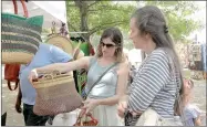  ??  ?? Kriscinda Sallee and Brenda Wilkins, both of Guthrie, Okla., look over baskets at the booth Treasures from Africa from Fayettevil­le during the 2017 Clotheslin­e Fair. The booth has been a regular at the Clotheslin­e Fair for four years.