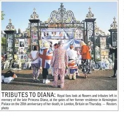  ??  ?? Royal fans look at flowers and tributes left in memory of the late Princess Diana, at the gates of her former residence in Kensington Palace on the 20th anniversar­y of her death, in London, Britain on Thursday. — Reuters photo