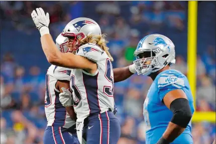  ?? PAUL SANCYA/AP PHOTO ?? New England Patriots defensive lineman Chase Winovich celebrates his quarterbac­k sack with a teammate during the second half of a preseason game Thursday against the Detroit Lions.