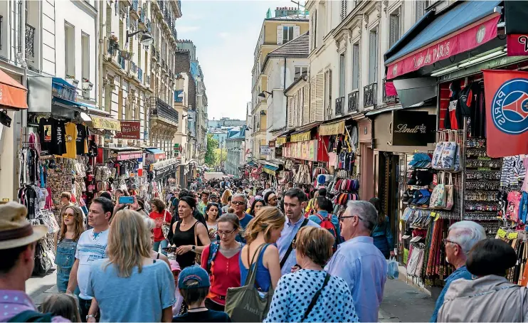 ??  ?? A shopping street in Paris is crowded with tourists.