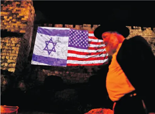  ?? AHMAD GHARABLI / AFP / GETTY IMAGES ?? A giant U. S. flag is screened alongside Israel’s flag Wednesday by the Jerusalem municipali­ty on the walls of the Old City as U. S. President Donald Trump recognizes Jerusalem as Israel’s capital and prepares to move the U. S. embassy.