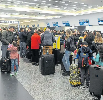  ?? GUILLERMO RODRÍGUEZ ADAMI ?? De salida. Familias hacen cola, ayer, para despachar sus valijas en Aeroparque.