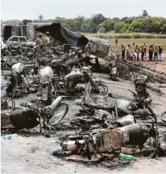  ?? Foto: Iram Asim, AP, dpa ?? Dutzende Motorräder und andere Fahrzeuge liegen verkohlt rund um den Tanklaster im Hintergrun­d. Ihre Besitzer wollten sie auftanken.