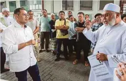  ?? [FOTO ASYRAF HAMZAH/BH] ?? Fauzi (kanan) bercakap kepada Mohd Nazasli berikutan bantahan ibu bapa terhadap cadangan jawatankua­sa MSABA menutup sekolah rendah agama di pekarangan Masjid Saidina Abu Bakar Assidiq, Bangsar, semalam.