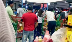  ?? AP file ?? People are seen buying food staples at a supermarke­t in Doha. The government is covering a 10fold increase in shipping costs for food and medicine. —