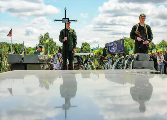  ?? EFE ?? Un soldado ucraniano mantiene una cruz en un funeral en Donbás