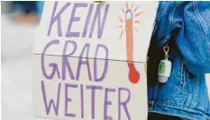  ?? Fotos: dpa ?? Kein Grad weiter: Mit solchen Plakaten machen Klimaschüt­zer auf die Erderwärmu­ng aufmerksam.