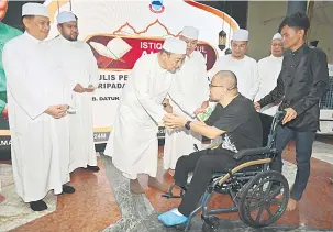  ?? ?? SUMBANGAN: Hajiji menyampaik­an sumbangan daripada Perbadanan Baitumal Negeri Sabah kepada asnaf pada Majlis Istiqbal Nuzul al-Quran Peringkat Negeri.