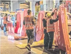  ?? Photo — AFP ?? Workers instal barriers to block an area amid the Covid-19 coronaviru­s pandemic in Guangzhou in China’s southern Guangdong province.