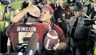  ?? Stephen M. Dowell / Orlando Sentinel / MCT ?? Head coach Jimbo Fisher hugs quarterbac­k Jameis Winston after Florida State held on. Winston led the Seminoles to touchdowns on three of their first four second-half drives.