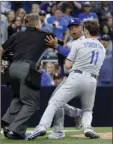  ?? PHOTO/GREGORY BULL ?? Los Angeles Dodgers manager Dave Roberts (center), is held back by third baseman Logan Forsythe (11) and home plate umpire Greg Gibson (left) as the Dodgers and the San Diego Padres come onto the field during an argument. AP