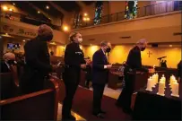  ?? ?? Los Angeles Police Chief Michel Moore, right, lights a candle Monday during the First AME Church's vigil.