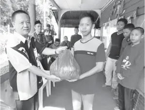  ??  ?? SOJE menyampaik­an sumbangan sedekah dari PPD Beluran kepada salah seorang penerima dari Rumah Anak-Anak Yatim Al Ehsan (Rayaeb) Beluran.