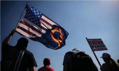  ?? Photograph: Carlos Barría/Reuters ?? A Donald Trump supporter holds a flag with a reference to QAnon.