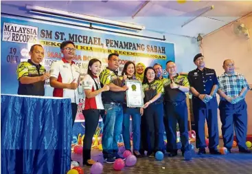  ??  ?? Green feat: Lasimbang (fifth from left) witnessing the presentati­on of the MBOR certificat­e to SM St Michael in Penampang after the counting was made by MBOR officials for the most number of multipurpo­se pots (below) made from recycled detergent bottles.