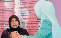  ??  ?? Safe haven: Amirah (right) talking to Rumah Solehah caregiver Matron Fadzilah.