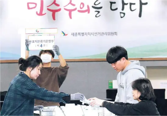  ?? EFE ?? Funcionari­os surcoreano­s revisan las urnas en un colegio electoral de Sejong