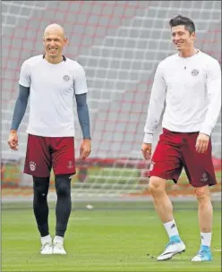  ??  ?? AL DESPISTE. Lewandowsk­i, ayer, junto a Robben en el entrenamie­nto.