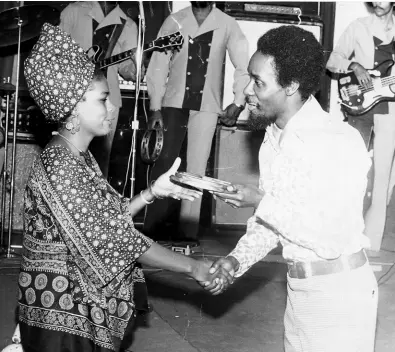  ??  ?? 1973: Top female vocalist for 1972, Judy Mowatt receiving her award from Minister of Trade and Tourism, PJ Patterson, at the Swing Awards Ball held at the Kingston Sheraton Ballroom in May.