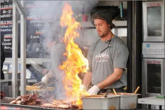  ?? Daily Courier file photo ?? Craig Rowe of Blazin BBQ cooks up ribs during last year’s RibFest in Kelowna.The second annual Interior Savings Sunrise Rotary RibFest is set for this Friday, Saturday and Sunday in City Park.