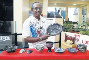  ??  ?? David Dunn displaying a piece of his exquisite ceramic items.