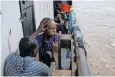  ?? ?? A PASSENGER gets his hair done on the gangway of a metal whaleboat