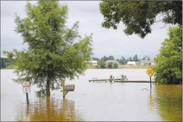  ??  ?? Floodwater­s from Lake Conway (top photo) cover Shoreline Drive in Mayflower on June 6. The road is dry now (lower photo), but the flood “changed lives for people who didn’t even know they were vulnerable,” Faulkner County’s County Judge Jim Baker said recently.