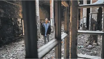  ?? VADIM GHIRDA/AP ?? Florin Catanescu walks through the ruins of the state orphanage that was his home as a child in Busteni, Romania. Now he runs a home for boys released from state care.