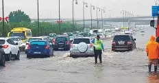  ?? Courtesy: Sharjah Police ?? A Sharjah Policeman braves the rain to direct traffic.