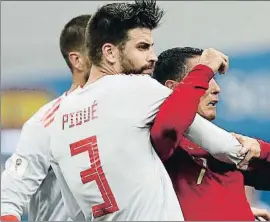  ?? ADRIAN DENNIS / AFP ?? Gerard Piqué forcejea con Cristiano