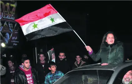  ?? George Ourfalian / AFP ?? Syrians celebrate after the army said it had retaken full control of Aleppo, the country’s second largest city.