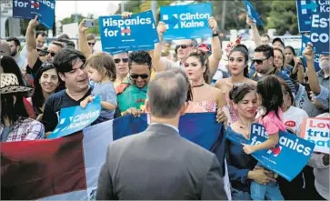  ?? Brendan Smialowski AFP/Getty Images ?? SUPPORTERS of Hillary Clinton wait near West Miami City Hall, an early-voting site where the candidate was greeting people. She also traveled Saturday to Pennsylvan­ia, a battlegrou­nd state without early voting.