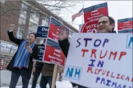  ?? N.H., Tuesday. DAVID GOLDMAN — THE ASSOCIATED PRESS ?? Former presidenti­al candidate and businessma­n Andrew Yang, left, cheers while campaignin­g outside a polling site for Democratic presidenti­al candidate Rep. Dean Phillips, D-Minn., as voting is underway in the New Hampshire presidenti­al primary in Manchester,