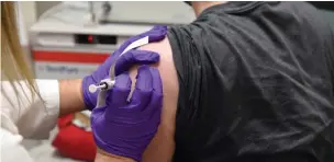  ?? Associated Press ?? This May 4 photo provided by the University of Maryland School of Medicine shows the first patient enrolled in Pfizer’s COVID-19 coronaviru­s vaccine clinical trial at the University of Maryland School of Medicine in Baltimore as he receives an injection.