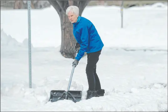  ?? David Zalubowski The Associated Press ?? A woman cleans the walkway around her home Friday in Littleton, Colo., after a storm brought up to 10 inches of snow to the Denver area. The highest reported accumulati­on from the storm so far was 53 inches in Nederland, a mountain town near Boulder.