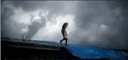  ?? RAMON ESPINOSA — THE ASSOCIATED PRESS ?? Trevon Laing walks the roof of his house to repair the damage made by Hurricane Dorian, in Gold Rock Creek, Grand Bahama, Bahamas, Thursday. Trevor says “After the hurricane they had me for dead, My momma was crying.”