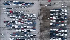  ?? JEFF ROBERSON — THE ASSOCIATED PRESS ?? In this aerial photo, mid-sized pickup trucks and full-size vans are seen in a parking lot outside a General Motors assembly plant where they are produced Wednesday, March
24, in Wentzville, Mo. The global shortage of semiconduc­tors is forcing General Motors to further cut production at six North American factories as chip supplies seem to be growing tighter. The shutdowns likely will crimp dealer inventory of vehicles made at the plants, but GM says it has managed to keep factories humming that make hot-selling and profitable full-size pickup trucks and SUVs.