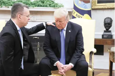  ?? | JACQUELYN MARTIN | AP ?? AMERICAN pastor Andrew Brunson lays his hand on US President Donald Trump in the Oval Office at the weekend. Brunson was released from Turkey on Friday after being convicted on charges of terrorism links by a Turkish court. Turkey’s government then freed him after he had been imprisoned for nearly two years. Brunson has denied the charges.