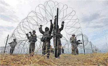  ?? [AP PHOTO] ?? Members of a U.S Army engineerin­g brigade place concertina wire around an encampment for troops, Department of Defense and U.S. Customs and Border Protection personnel, Nov. 4 near the U.S.-Mexico Internatio­nal bridge in Donna, Texas.