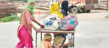  ?? Agence France-presse ?? ↑
Migrants wait for transporta­tion in Allahabad, UP, on Sunday.