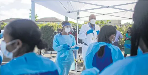  ??  ?? WE’RE RUNNING OUT: Medical staff at a drive-through testing site in West Palm Beach, Fla, last week. Doctors and nurses are rallying for more personal protective gear.