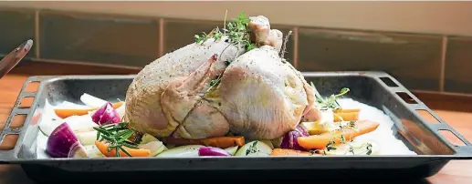  ??  ?? Arrange the sliced lemon, onions and carrots on a lined baking tray to make a bed for the chicken.