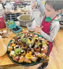  ?? Courtesy Photos/Ryan Cayer ?? Calvin Cayer, 7, cooks in a class taught by Brian O’Rourke, 73, the retired former owner of O’Rourke’s Diner on Main Street in Middletown. At left, O’Rourke and Cayer show off some baked goods they made together.