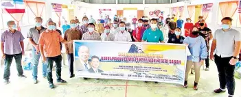  ??  ?? Dr Joachim (front, sixth left) during the handover ceremony in Ranau yesterday.