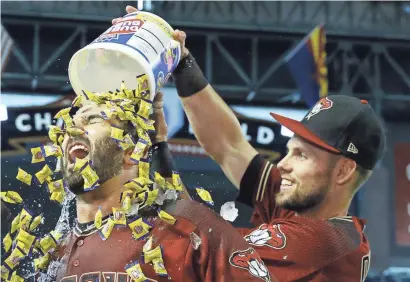  ?? PHOTOS BY DAVID KADLUBOWSK­I/AZCENTRAL SPORTS ?? Diamondbac­ks outfielder Chris Owings (right) showers Daniel Descalso following Descalso’s walk-off RBI single against the Phillies in the 11th inning at Chase Field in Phoenix on Sunday afternoon.