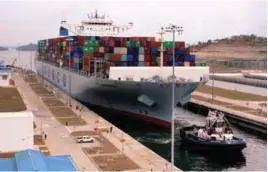  ??  ?? ... The container ship COSCO Developmen­t is seen as it becomes the largest vessel in dimension and capacity to transit the expanded Panama Canal at Agua Clara locks, on the outskirts of Colon City, Panama, on May 2.