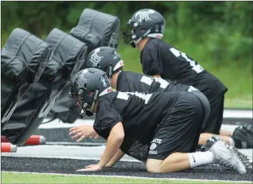  ??  ?? PHOTOS BY JUSTIN MANNING/CONTRIBUTI­NG PHOTOGRAPH­ER Seth Everett, front, leads a blocking drill during practice.